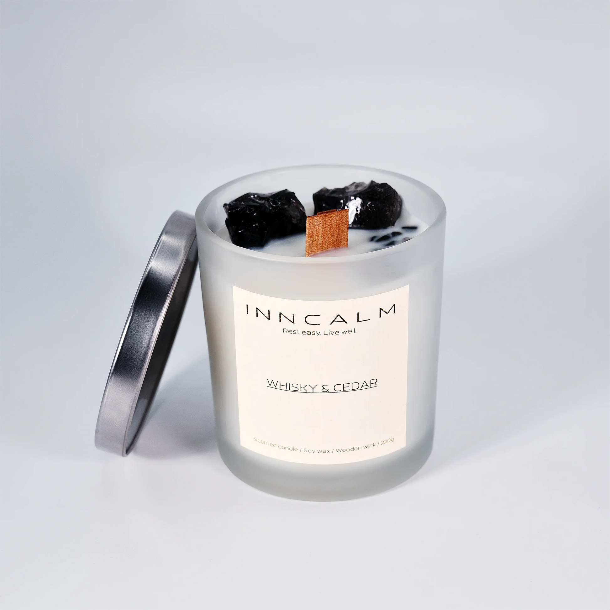 Luxury scented candle with a stylish glass lid, designed to preserve the deep, smoky fragrance of whiskey and cedar.